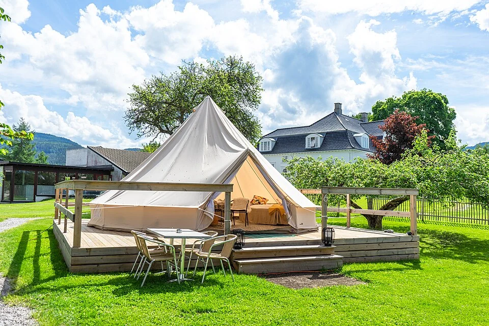 Een ingerichte glampingtent op een houten terras bij Thorbjørnrud