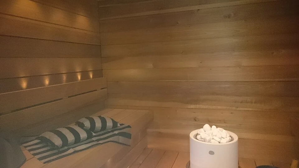 Een houten sauna met banken en saunakachel